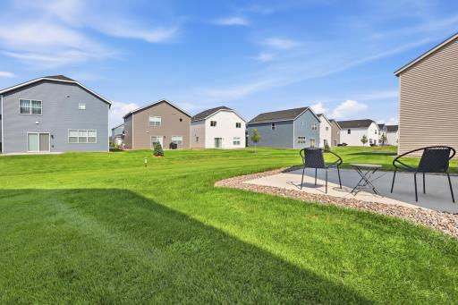 Inviting backyard patio with plenty of open lawn space for relaxing, entertaining, and outdoor activities