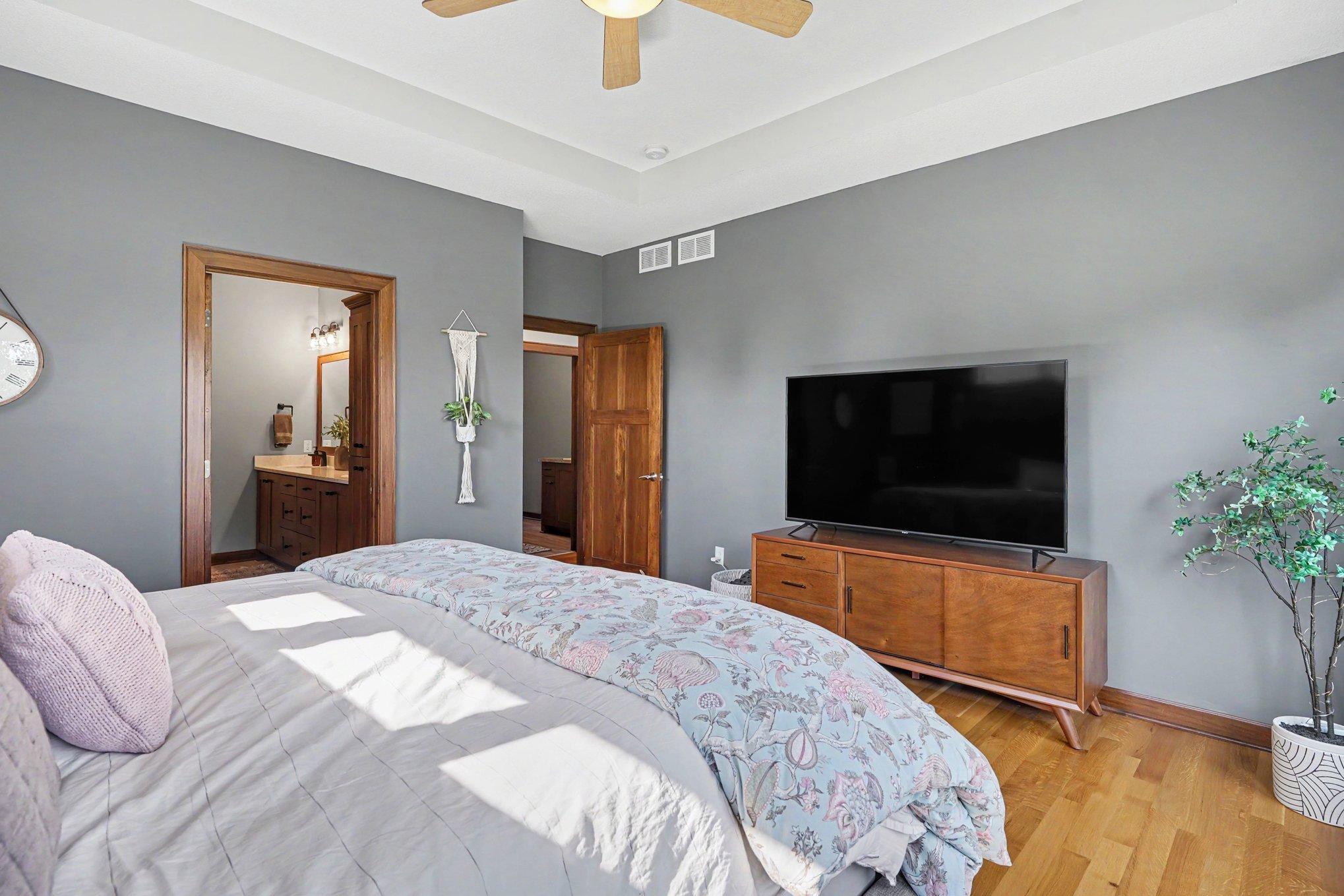 Another view of the primary bedroom shows you access to the private ensuite bathroom and the entryway into the laundry room and mudroom with access to the garage.