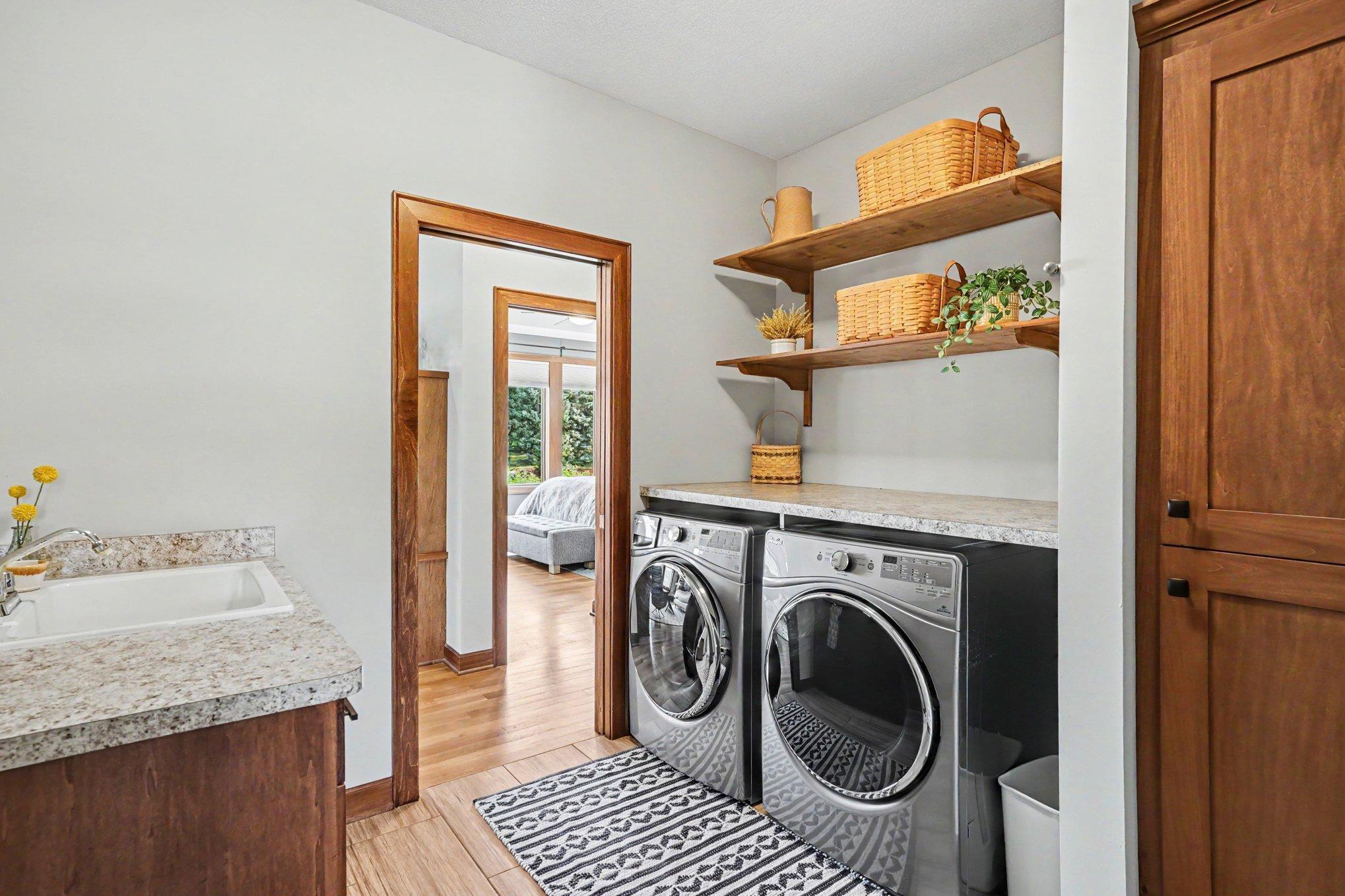 The convenient laundry room is located off the living room with a pocket door and connects to the back mud room and entry into the 3 car garage. There is a utility sink, built-in cabinets and a huge walk-in closet in this room.