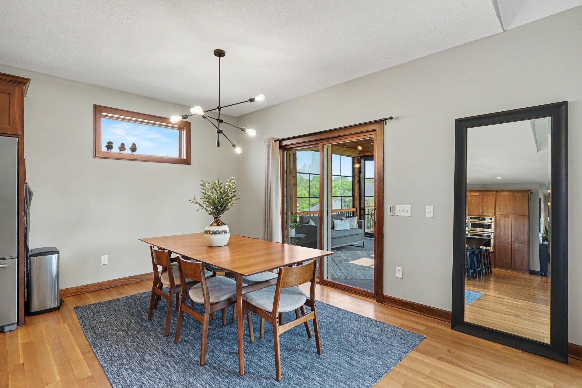The informal dining room has ample space for entertaining and has a new modern light fixture and access to the sunroom through the sliding glass door.