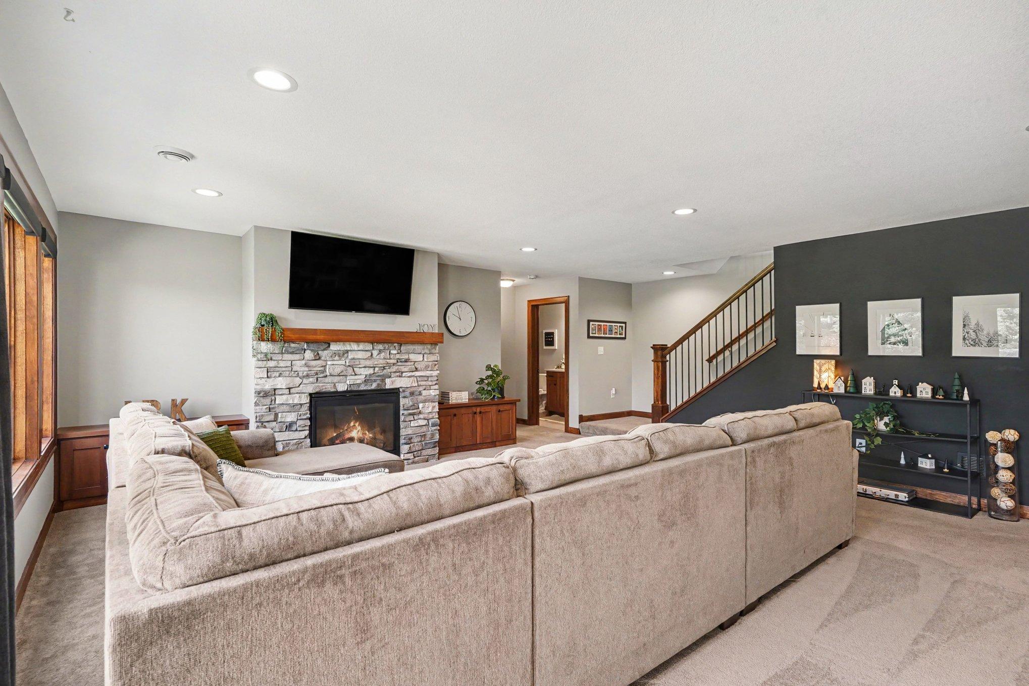 Built-in storage benches adorn each side of the stone stacked gas fireplace.