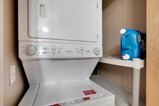 Stacked washer and dryer is located conveniently in the main level owner's bath laundry closet.