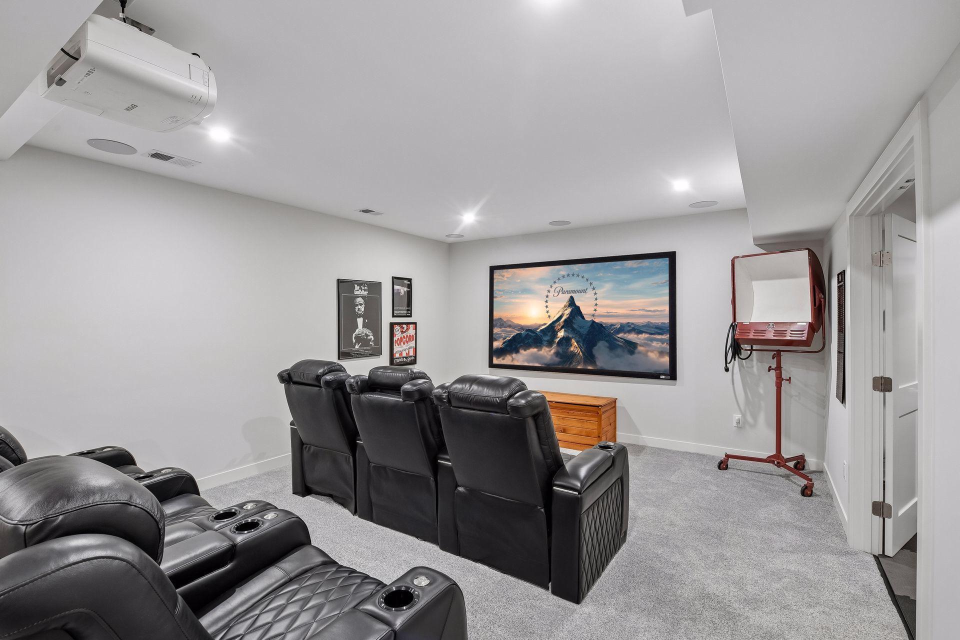 Dedicated theater room features projector, screen, and surround sound