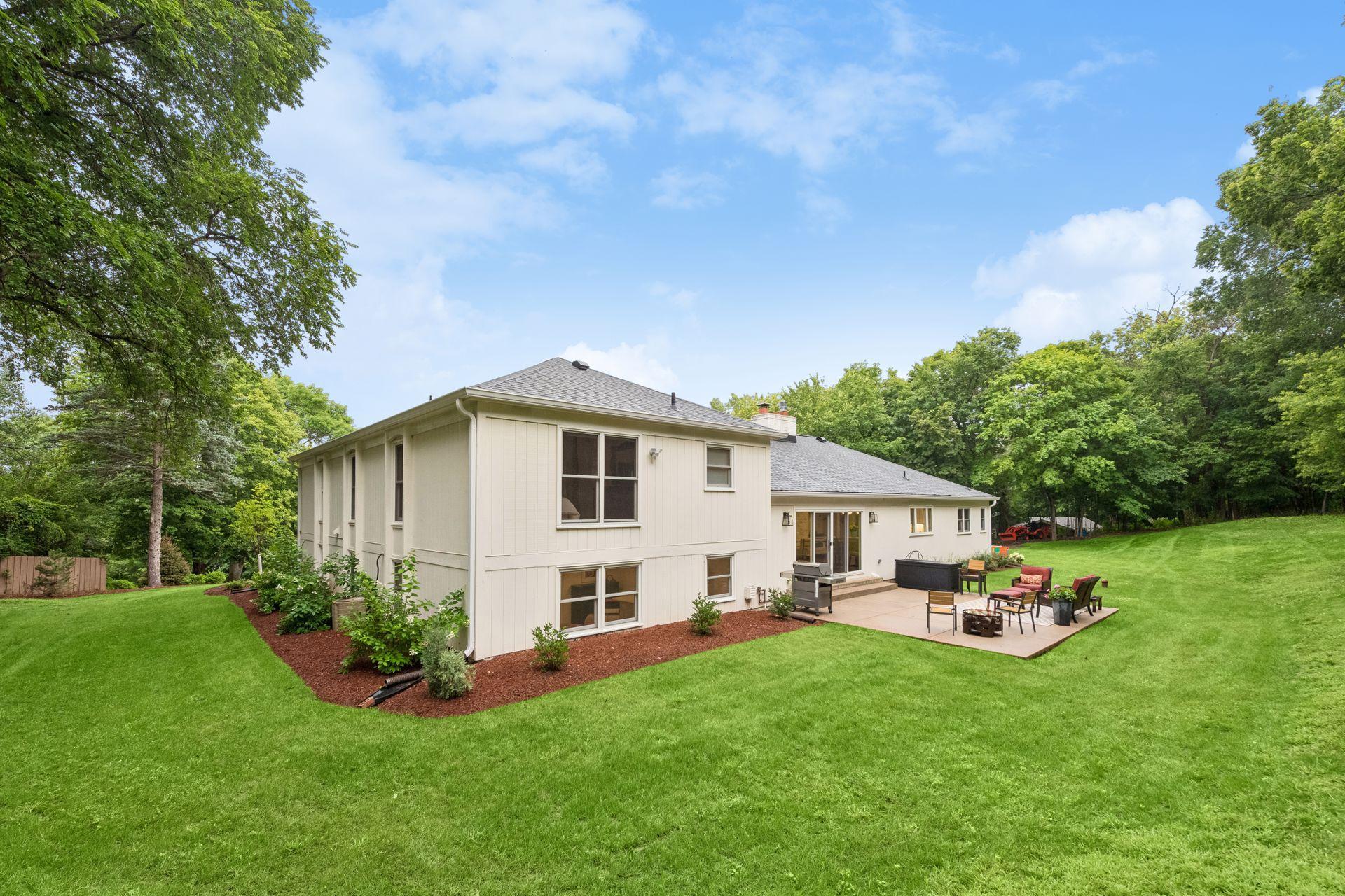 Expansive backyard offers beautiful lawn and mature tree surroundings