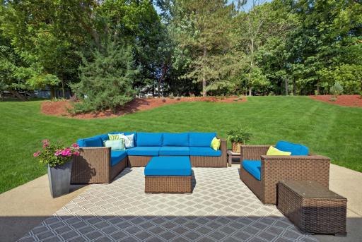 Spacious patio located off of the kitchen/informal dining area. Hydorseeding has been done to the lawn. This picture has been AI enhanced.