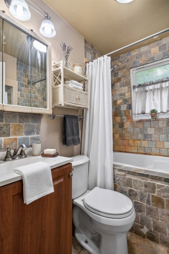 Full bathroom virtually staged with towels and knick knacks