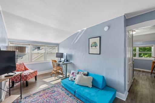 The sunny living room offers enough space for both lounging and a dedicated work-from-home area.