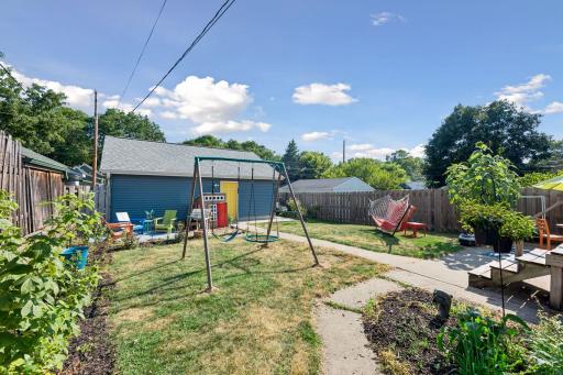 Established garden beds add color and character to the backyard, with the detached garage just steps away.