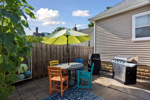 A patio tucked alongside the home creates a dedicated spot for outdoor dining and grilling.