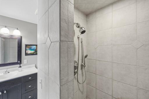 The tiled walk-in shower adds a spa-like touch to your daily routine.