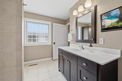 The beautifully updated primary bath features dual sinks and generous storage.