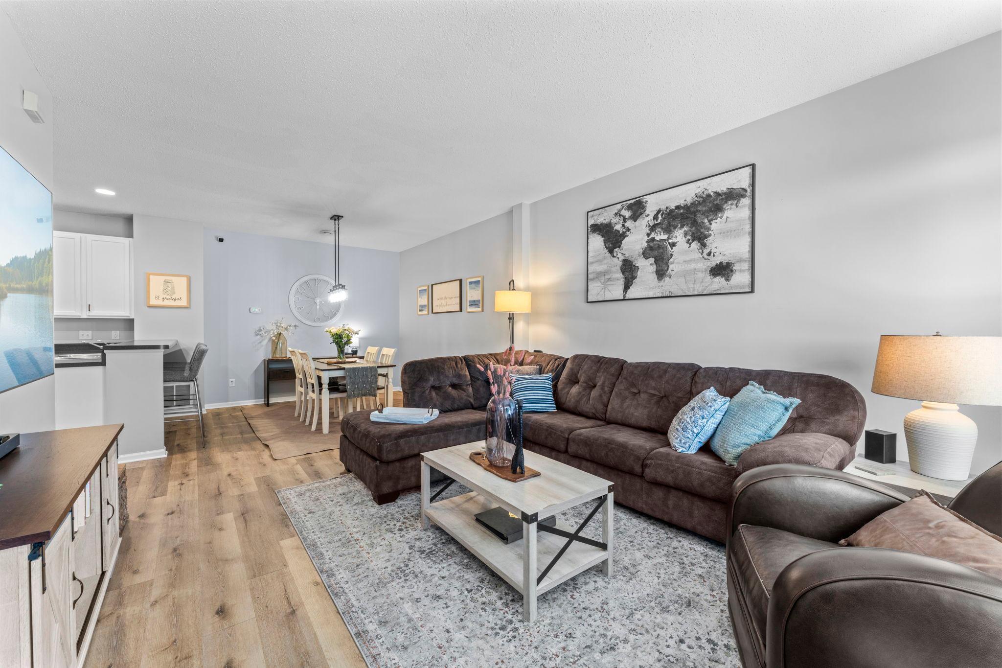 The spacious living room makes a welcoming first impression with updated laminate flooring (2025).