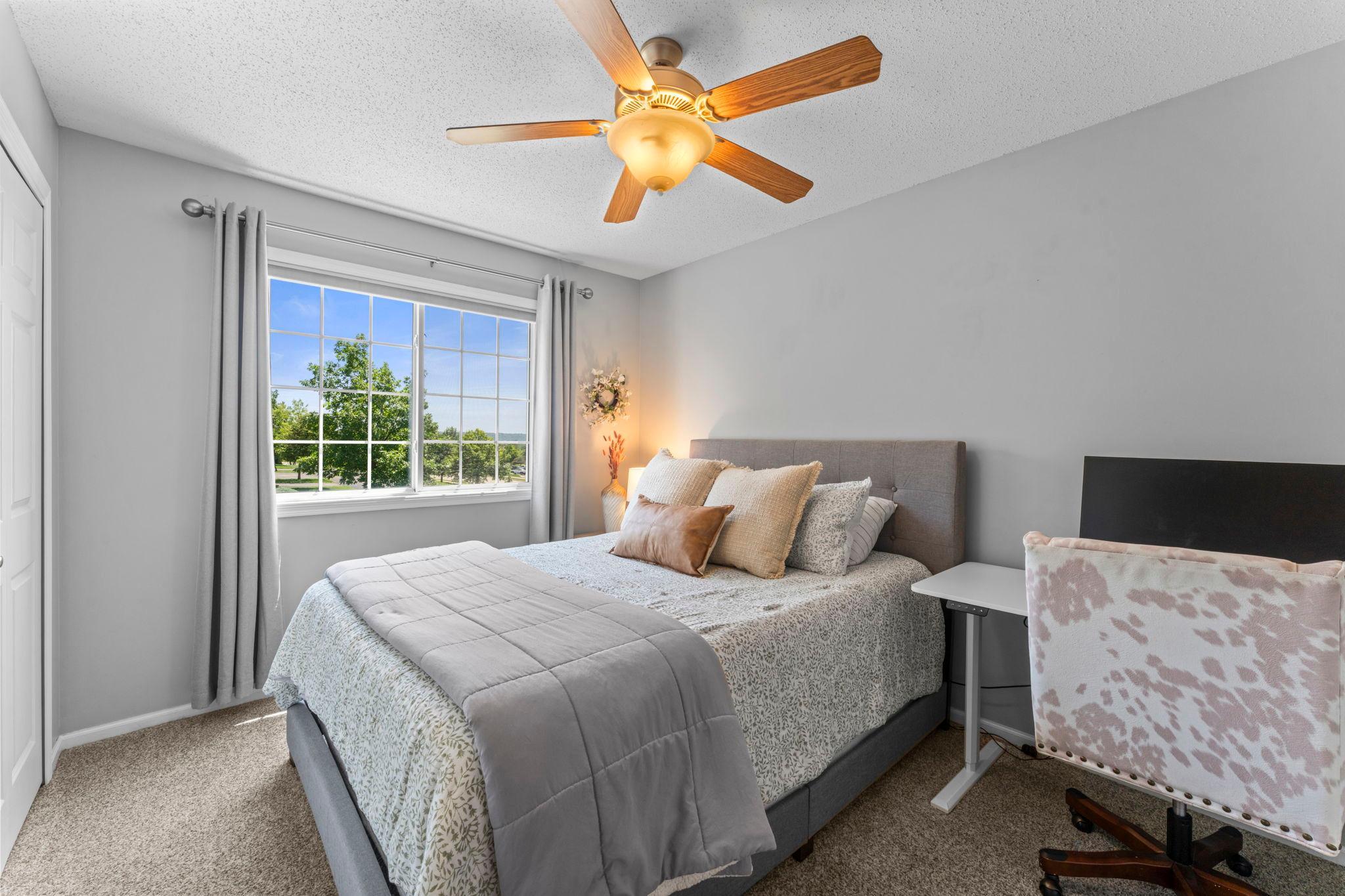 Two comfortable bedrooms complete the upper level, each with plush carpeting and ceiling fans.