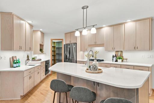 A streamlined cooking space pairs warm cabinetry with bright countertops and modern appliances.