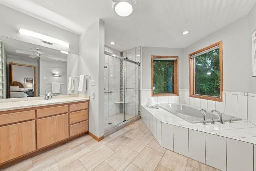 The primary bath features a glass-enclosed shower, soaking tub, and abundant natural light.