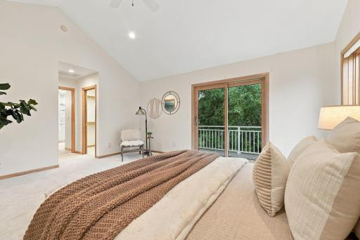 Vaulted ceilings and deck access give the primary bedroom an airy sense of space.