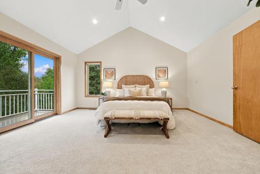Large windows bring natural light and leafy views into the primary suite.