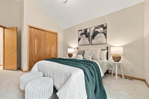 A spacious bedroom with natural light and classic wood detailing.