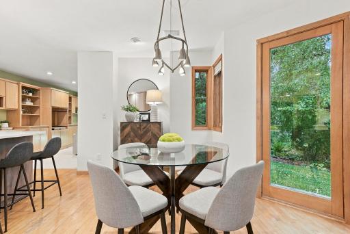 The informal dining area is surrounded by windows and views of the landscaped yard.