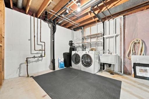 The lower-level laundry area offers generous space for everyday tasks and storage.