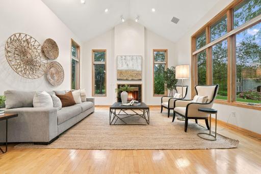 Soaring ceilings, hardwood floors, and dramatic windows bring warmth and natural light to the living room.