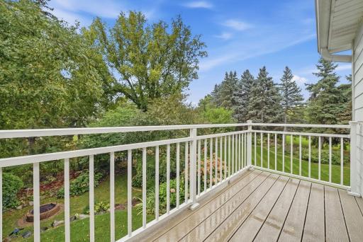The upper-level deck offers a peaceful place to enjoy the surrounding greenery.