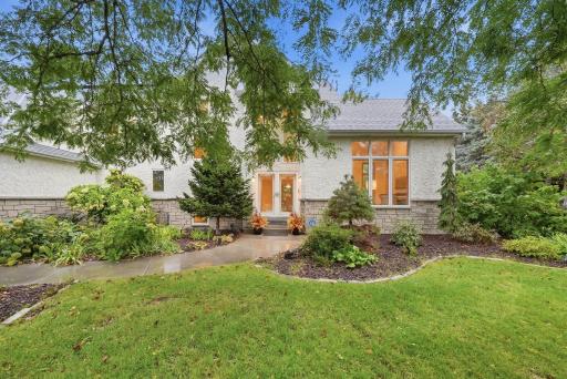 A beautifully landscaped Mendota Heights setting with mature trees and a welcoming approach.