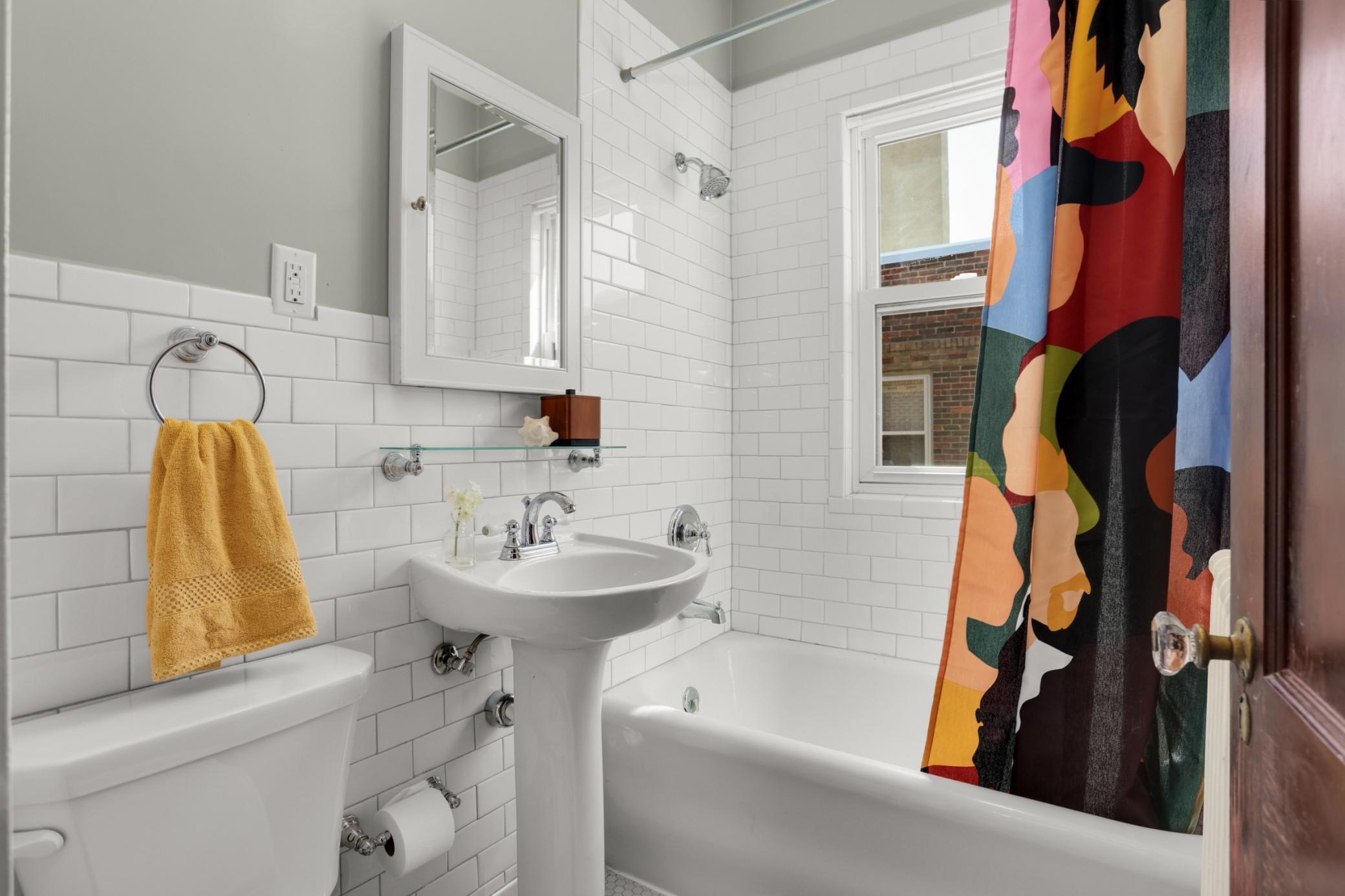The full bath features nice tile work and great light.