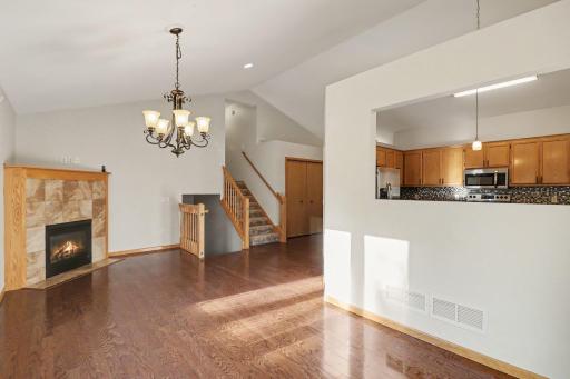 Second view of the main-level living room with vaulted ceiling and hardwood floors.