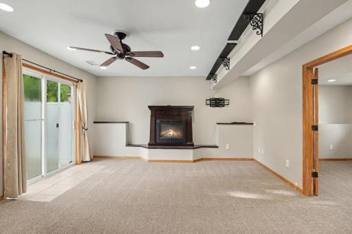 Additional view of lower-level family room with fireplace.