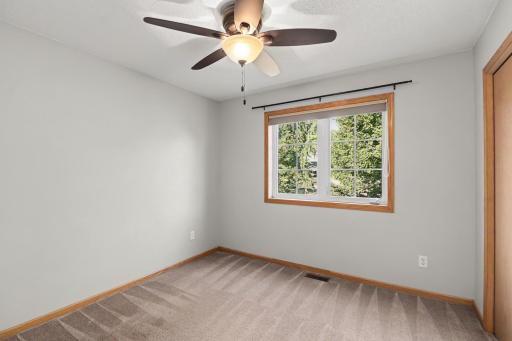Upper-level bedroom with fresh carpet and natural light.
