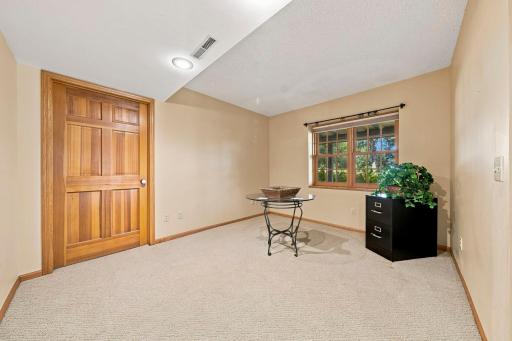 Lower level game room/office leading to the mechanical room with tons of storage.