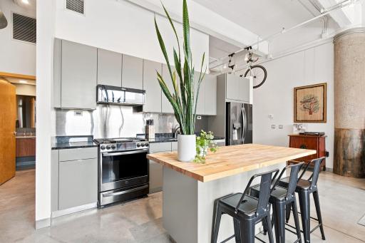 New cabinets, appliances, and an oversized island with barstool seating.