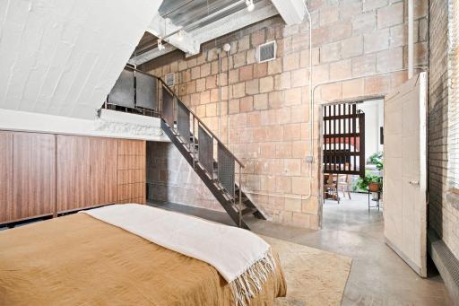 Vaulted ceilings, custom built-in closets with additional storage nook, and a hand-crafted industrial staircase leading up to the loft.
