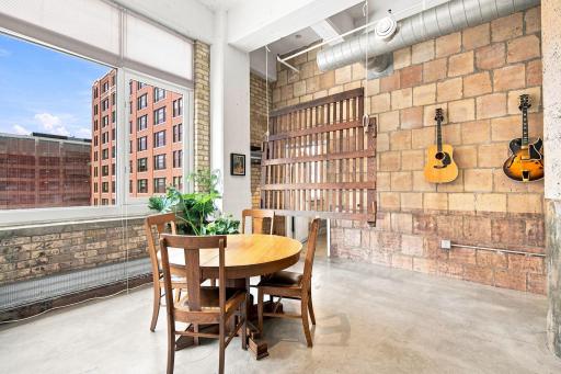 Dining room with downtown views. Exposed brick and ductwork are primary features of true loft living in the North Loop.