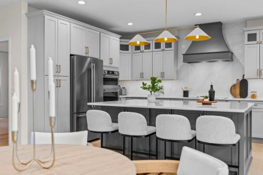 The kitchen island takes center stage with seating for five, bold pendant lighting, and premium finishes throughout.