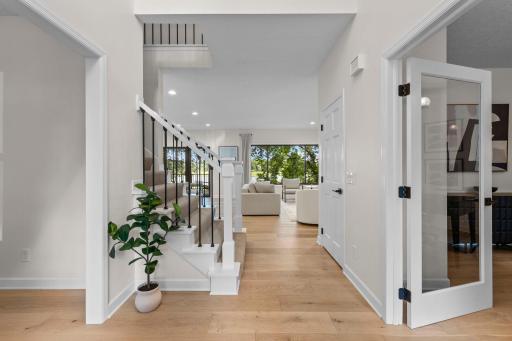 Light-filled foyer with soaring ceilings, gleaming hardwood floors, and an open sightline that draws you straight to the lake