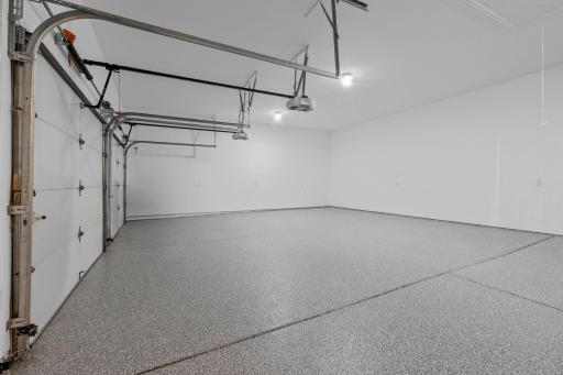Oversized three-car garage with epoxy-coated floors, high ceilings, and room for vehicles, storage, and all your recreational gear.