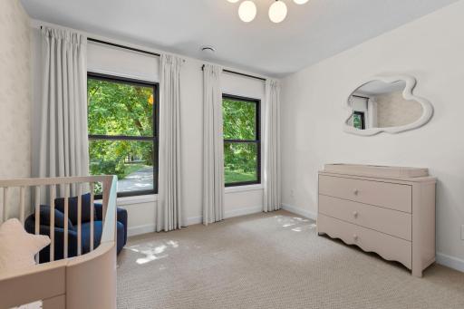 Secondary bedroom filled with natural light and lush green views, offering a comfortable and versatile space for family or guests.