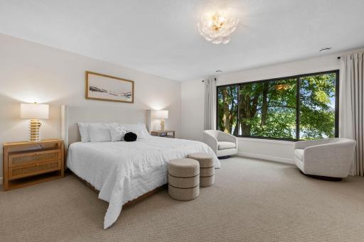 Wake up to treetop and lake views from this beautifully appointed primary suite, complete with oversized windows and a tranquil setting.