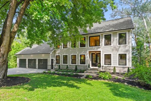 Side exterior view highlighting the home's generous footprint, three-car garage, large windows, and beautifully maintained grounds.