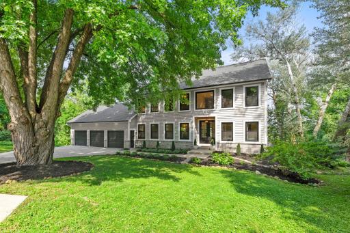Stunning curb appeal with classic architecture, lush grounds, and a serene natural setting right on the lake.