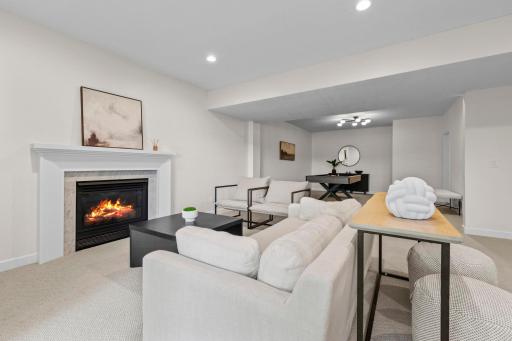 Lower level family room with a cozy gas fireplace, built-in workspace, and a warm, inviting layout ideal for movie nights or casual gatherings.