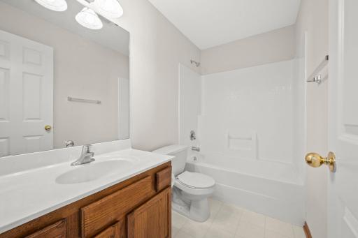 Upper-level full bath features a spacious vanity and tile floors