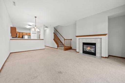 The fireplace creates a warm focal point in the comfortable living room, with an open layout that connects easily to the dining and kitchen areas