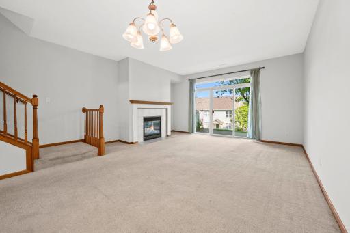 Bright and spacious living room with a cozy fireplace, large windows, and plenty of room to relax or gather with friends and family