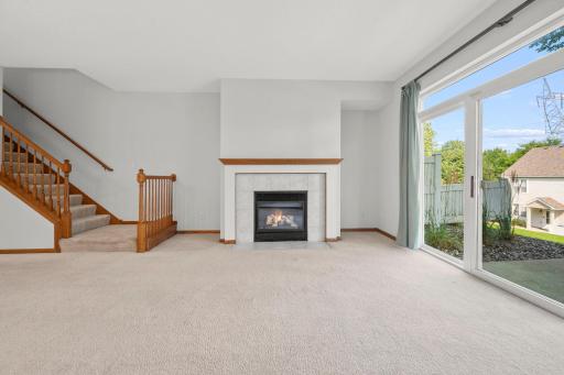 A warm and inviting gathering space with a gas fireplace, large sliding glass doors, and easy access to the backyard