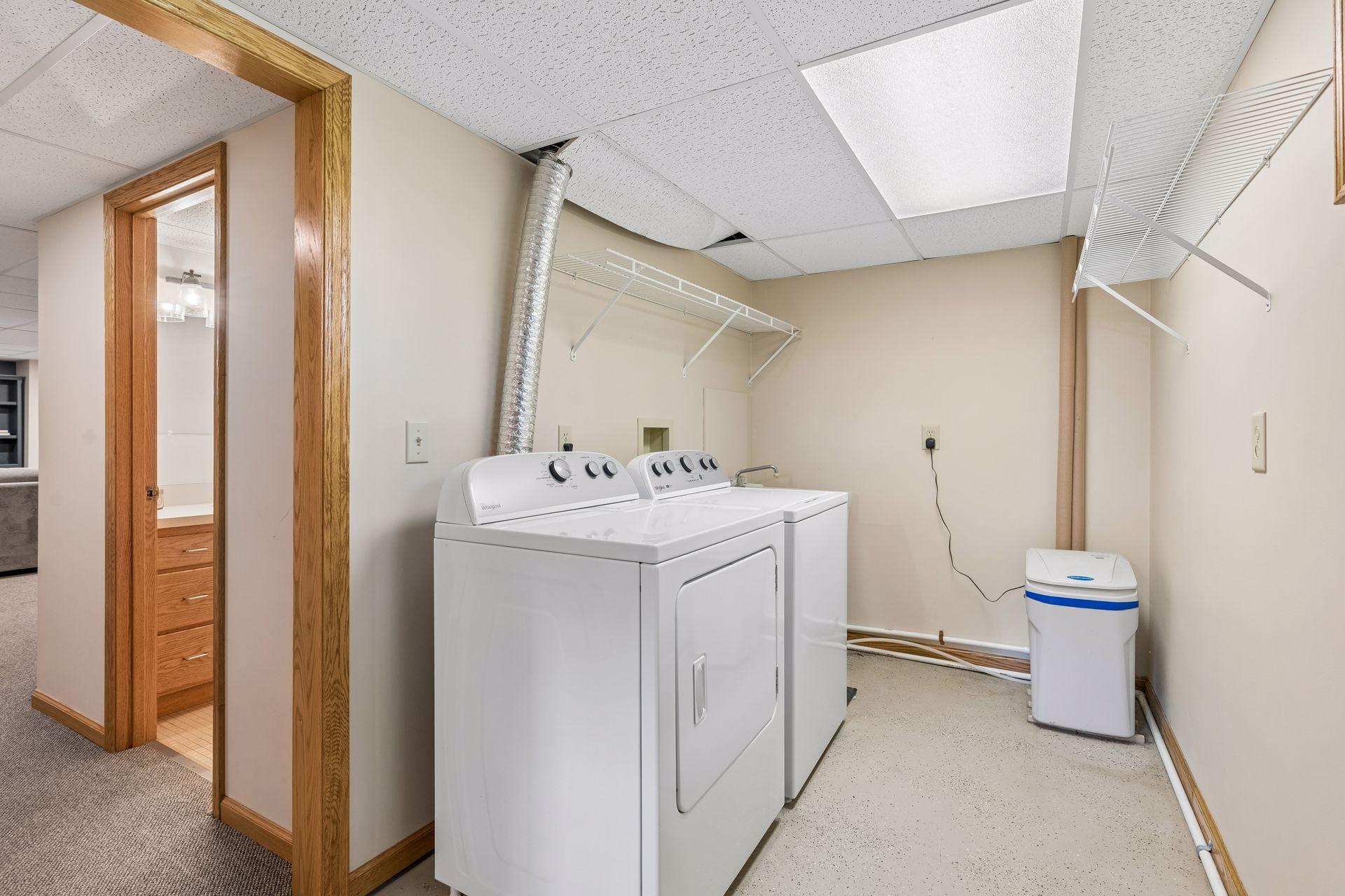 Nice laundry space with shelving and great lighting