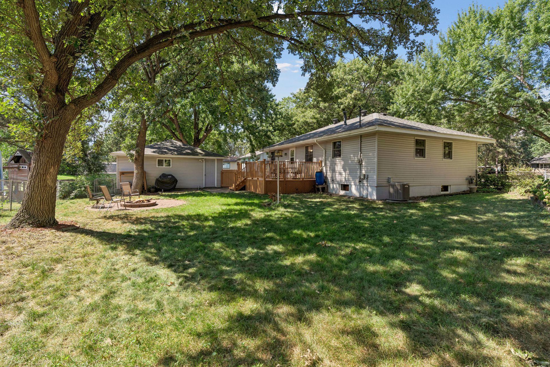 Spacious yard is fully fenced, firepit, oversize 2 stall detached garage and large deck