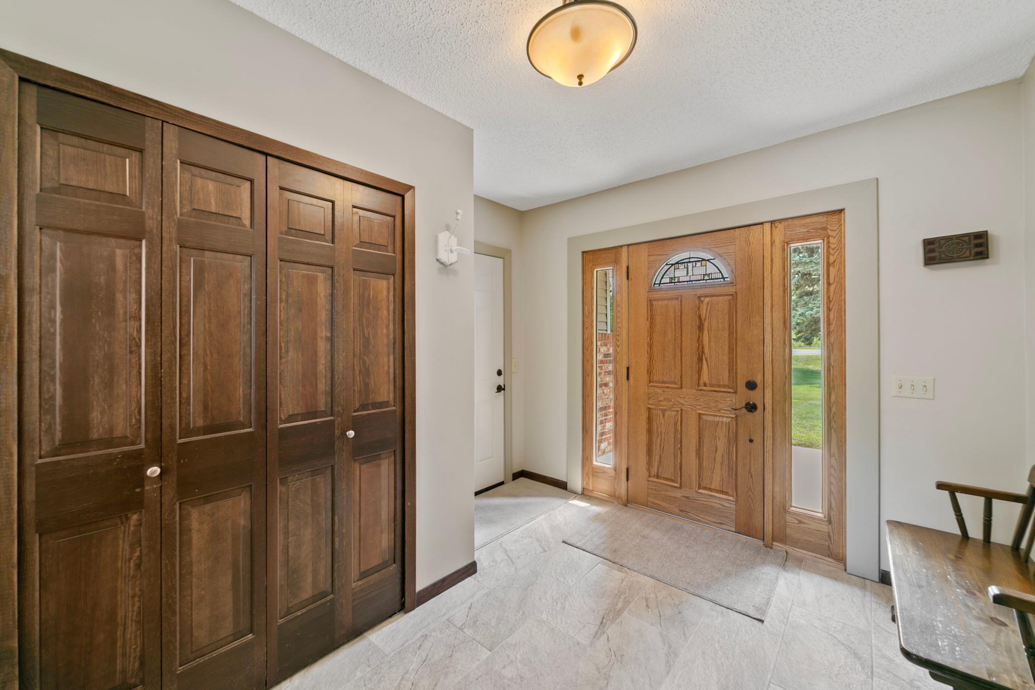 Newer front door and newer heated tile flooring in the entry